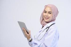 Female muslim doctor with hijab over white background studio. photo