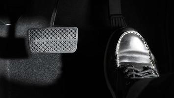 Accelerate and Brake. Foot pressing foot pedal of a car to drive ahead. photo