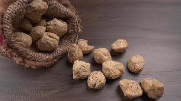 Raw soya chunks on dark background. Healthy, nutritious soybean meat, chunks isolated.Vegan food concept. photo