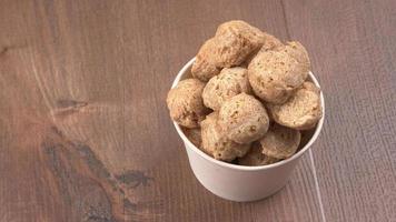 Raw soya chunks on dark background. Healthy, nutritious soybean meat, chunks isolated.Vegan food concept. photo