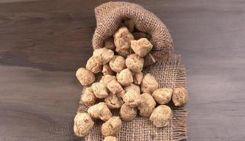 Raw soya chunks on dark background. Healthy, nutritious soybean meat, chunks isolated.Vegan food concept. photo