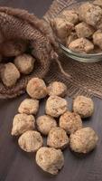 Raw soya chunks on dark background. Healthy, nutritious soybean meat, chunks isolated.Vegan food concept. photo