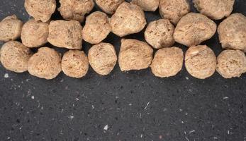 Raw soya chunks on dark background. Healthy, nutritious soybean meat, chunks isolated.Vegan food concept. photo