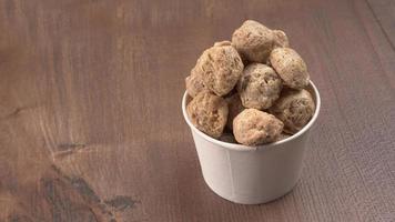 Raw soya chunks on dark background. Healthy, nutritious soybean meat, chunks isolated.Vegan food concept. photo