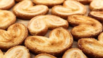 Galletas de palma de hojaldre fresco en forma de corazón. pasteles franceses clásicos. oreja de cerdo, galletas de oreja de elefante, corazones franceses. vista desde arriba foto