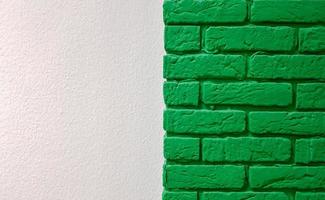 Modern new flat pink wall with a decorative brick column painted green. Abstract modern trendy texture background. Copy space empty space for your text and advertisement. photo