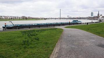 Dusseldorf, Germany - February 20, 2020. view of the Rhine river, promenade and bridge. View over a walk on the banks of the Rhine river in Dusseldorf on a clear spring day, North Rhine Westphalia. photo