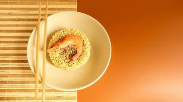 Spicy instant noodle soup with shrimp. shrimp soup, cooking, food. Raw dried circle-shaped vermicelli in a plate. Asian food. pasta, for the preparation of which it is enough to pour boiling water photo