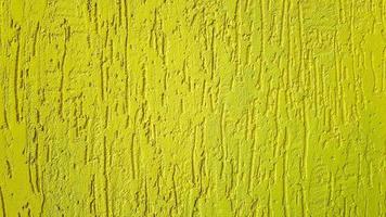 Old gold plaster wall texture yellow background. Textured textured wall plaster. Embossed wall decoration. Stucco walls. Embossed wall decoration. Decorative plaster is painted yellow. photo