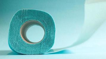 Blue roll of modern toilet paper on a blue background. A paper product on a cardboard sleeve, used for sanitary purposes from cellulose with cutouts for easy tearing. Embossed drawing photo