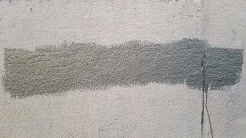 Gray concrete wall. Large coarse strokes of paint on the surface of the house. Close-up. Classic background. Copy space. Place for text. photo