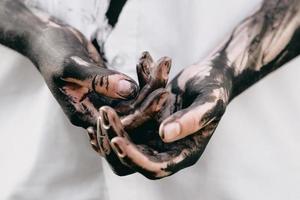 Dirty hands with black gold - oil. Pollution, eco, eco guilt, global warming, recycling concept photo