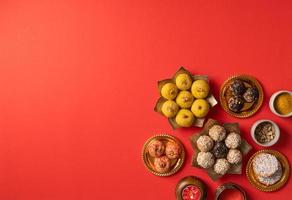 traditional indian sweets on red background flat lay photo