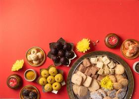 traditional indian sweets on red background flat lay photo