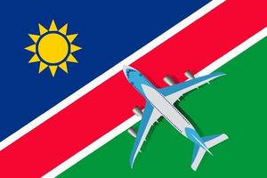 Plane and flag of Namibia. Travel concept for design. Vector Illustration of a passenger plane flying over the flag of Nabimia. The concept of tourism and travel