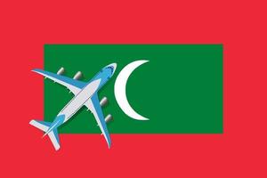 Vector Illustration of a passenger plane flying over the flag of the Maldives. Concept of tourism and travel