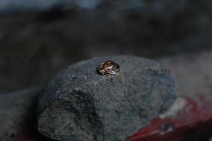A pair of wedding rings on rock photo