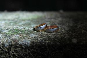 A pair of wedding rings on rock photo