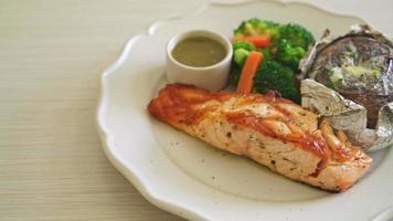grilled salmon steak with bake potato and vegetables