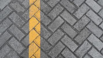 Paving slab gray urban street with yellow lines road markings stone tile texture background photo