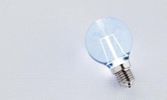 Light bulbs with incandescent bulbs glow blue on white draft office graph paper. Thinking and imagination idea concept. 3D illustration rendering photo