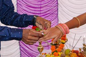 Wedding ritual of putting the ring on the finger in india. photo