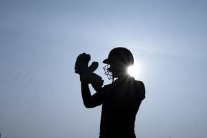Silhouette of a cricket player getting ready before the match in the evening. Indian cricket and sports concept.
