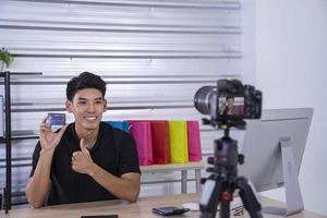 asian man blogger present and review product video broadcast live stream video to a social network. blogging, vlogging, online shopping, and social media concept photo