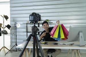 asian man blogger present and review product video broadcast live stream video to a social network. blogging, vlogging, online shopping, and social media concept photo