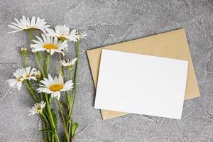 blank white greeting card and envelope with chamomile flowers photo