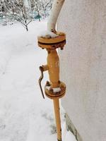 gas tap on the wall of a private house on a winter day photo