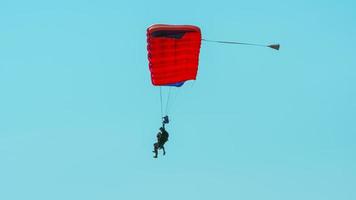 salto en paracaídas en tándem. silueta de paracaidista volando en un cielo azul claro.