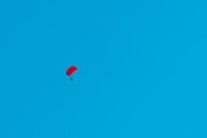 salto en paracaídas en tándem. silueta de paracaidista volando en un cielo azul claro.