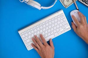 Businessman using computer, ffice desk table with computer tools and supplies. Top view with copy space, flat lay. photo
