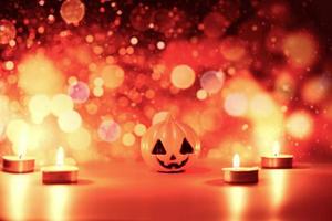 Halloween background candlelight orange decorated holidays festive concept - funny faces jack o lantern pumpkin halloween decorations for party accessories object with candle light bokeh photo