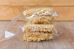 instant noodles in package on wooden background - dry food non perishable storage goods in kitchen home or for donations photo