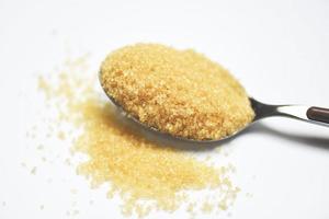 brown sugar in a spoon on white background photo