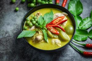 Thai food green curry on soup bowl with ingredient herb vegetable on dark plate background - green curry chicken cuisine asian food on the table photo