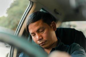 un hombre usa su teléfono mientras conduce y se queda dormido mientras conduce.
