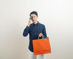 portrait young Asian man holding credit card and shopping bag photo