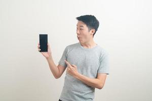 young Asian man using or talking smartphone and mobile phone photo