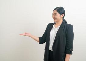 Asian woman with hand present on white wall photo