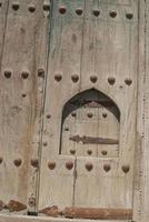 Puerta de madera antigua con remaches metálicos en bukhara, asia central. foto