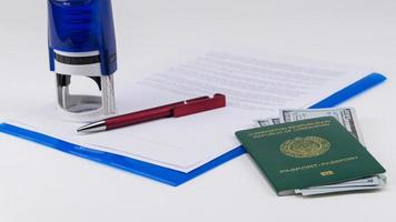 pasaporte de uzbekistán con dólares estadounidenses en el fondo de documentos y contrato. concepto - soborno y corrupción