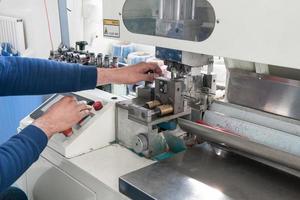 hands working on industrial machine for cutting cable photo