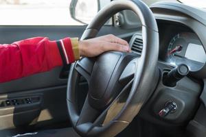 mano de hombre con un reloj en el volante de un coche moderno foto