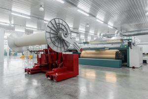 lifting hydraulic machine lifts large coils. textile and spinning mill photo