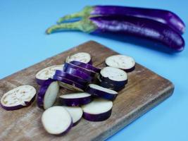 berenjena en rodajas sobre una tabla de cortar de madera. concepto vegetal saludable para la dieta foto