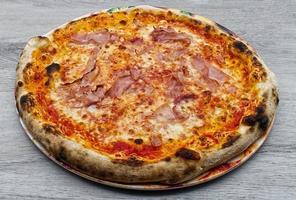 Italian Ham and Mozzarella cheese Pizza on wooden background. photo