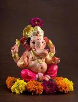 Hindu God Ganesha. Ganesha Idol on dark wooden background. photo